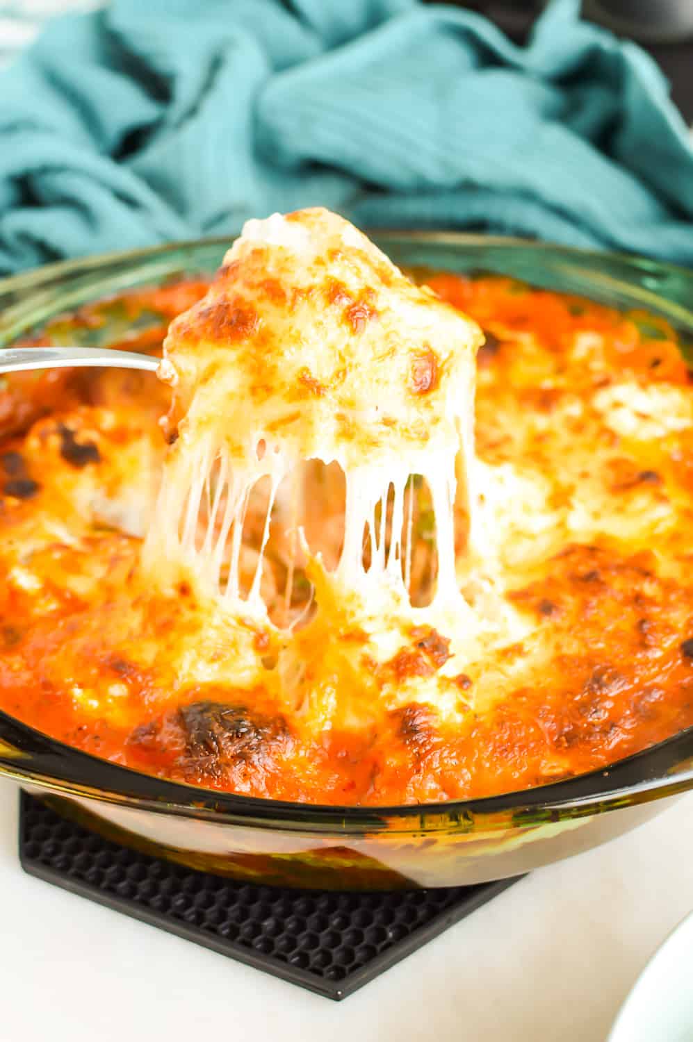 Serving spoon scooping Cheesy Meatball Bake from a casserole dish.