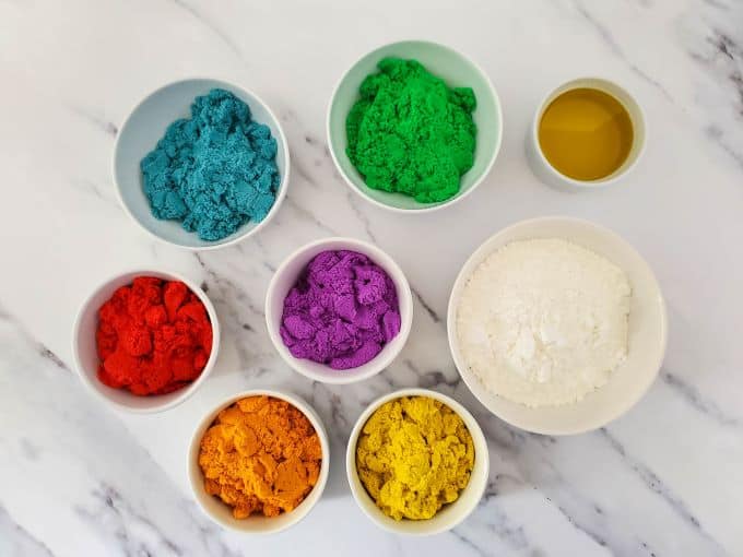 Bowls of materials for making rainbow kinetic sand.