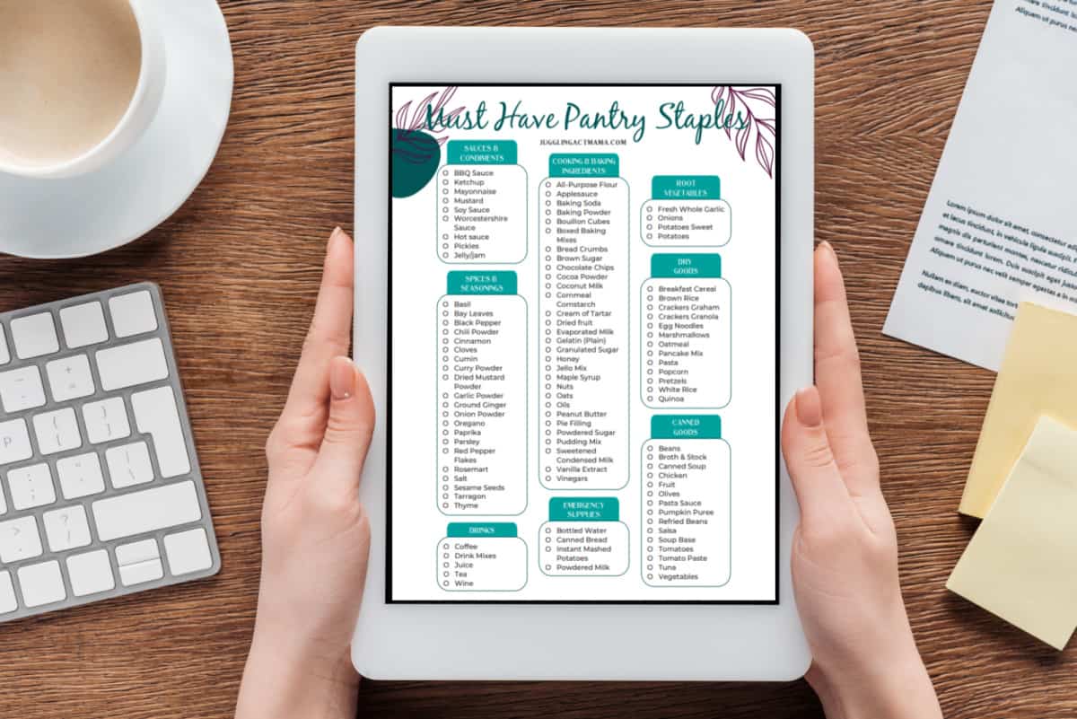 Hands holding a tablet showing a printable that reads Must Have Pantry Staples.