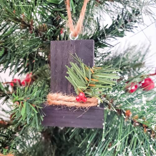 Close up of Snowman Hat Block Ornament hanging from a Christmas tree.