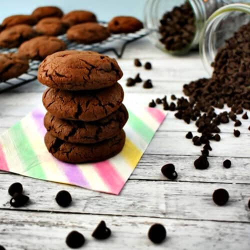 A stack of Double Chocolate Chip Cookies on a colorful napkin.