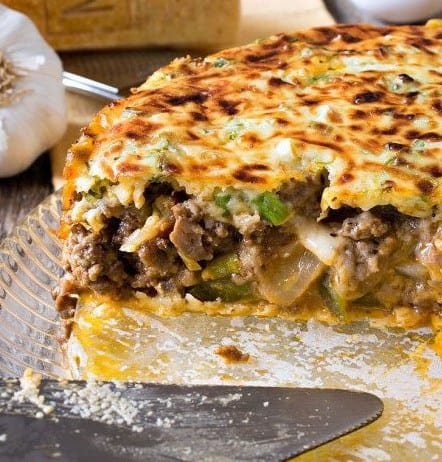Italian Beef and Sausage Pie in a baking dish with a pie server.