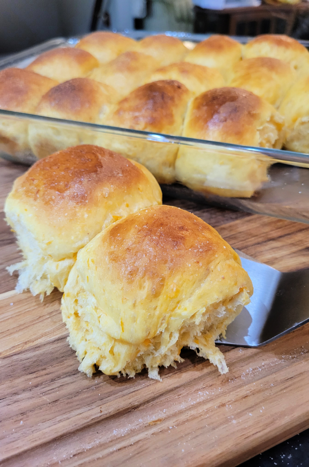 Close up of baked Sweet Potato Rolls on a cutting board.