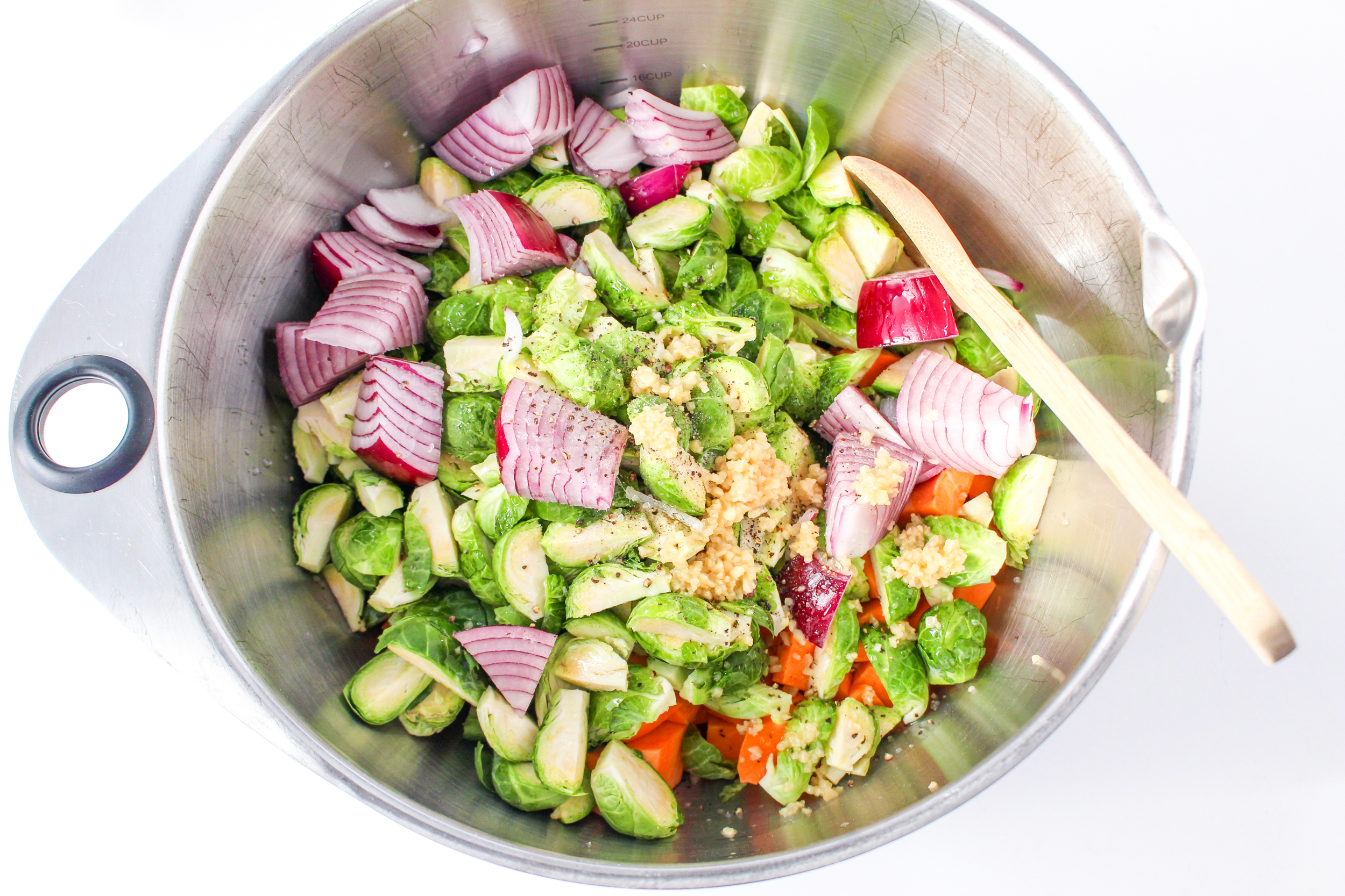 A large bowl of vegetables with fresh garlic.