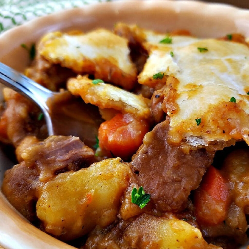 Close up of Beef Pot Pie in a bowl with a spoon.