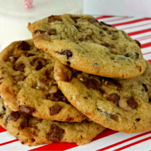 Pile of Chocolate Chip Toffee Cookies on a red and white striped plate.