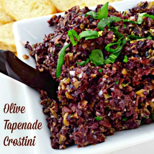 Bowl of Olive Tapenade Crostini garnished with fresh basil.