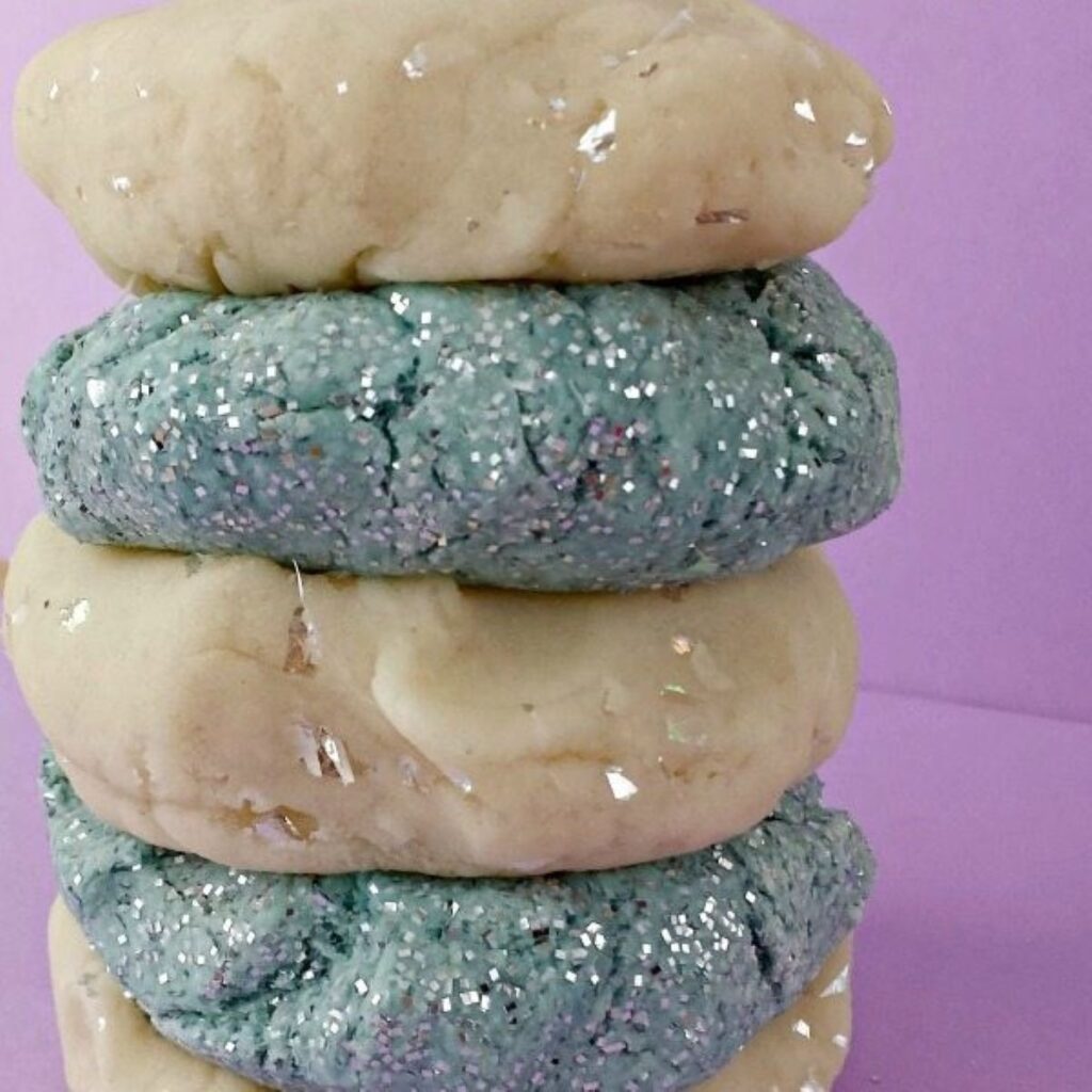 Stacked up Sparkle Playdough in different colors.