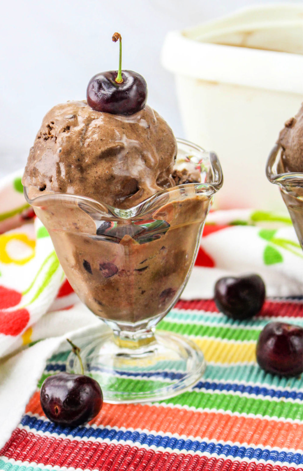 Black Forest Ice Cream in an ice cream dish with a cherry on top.