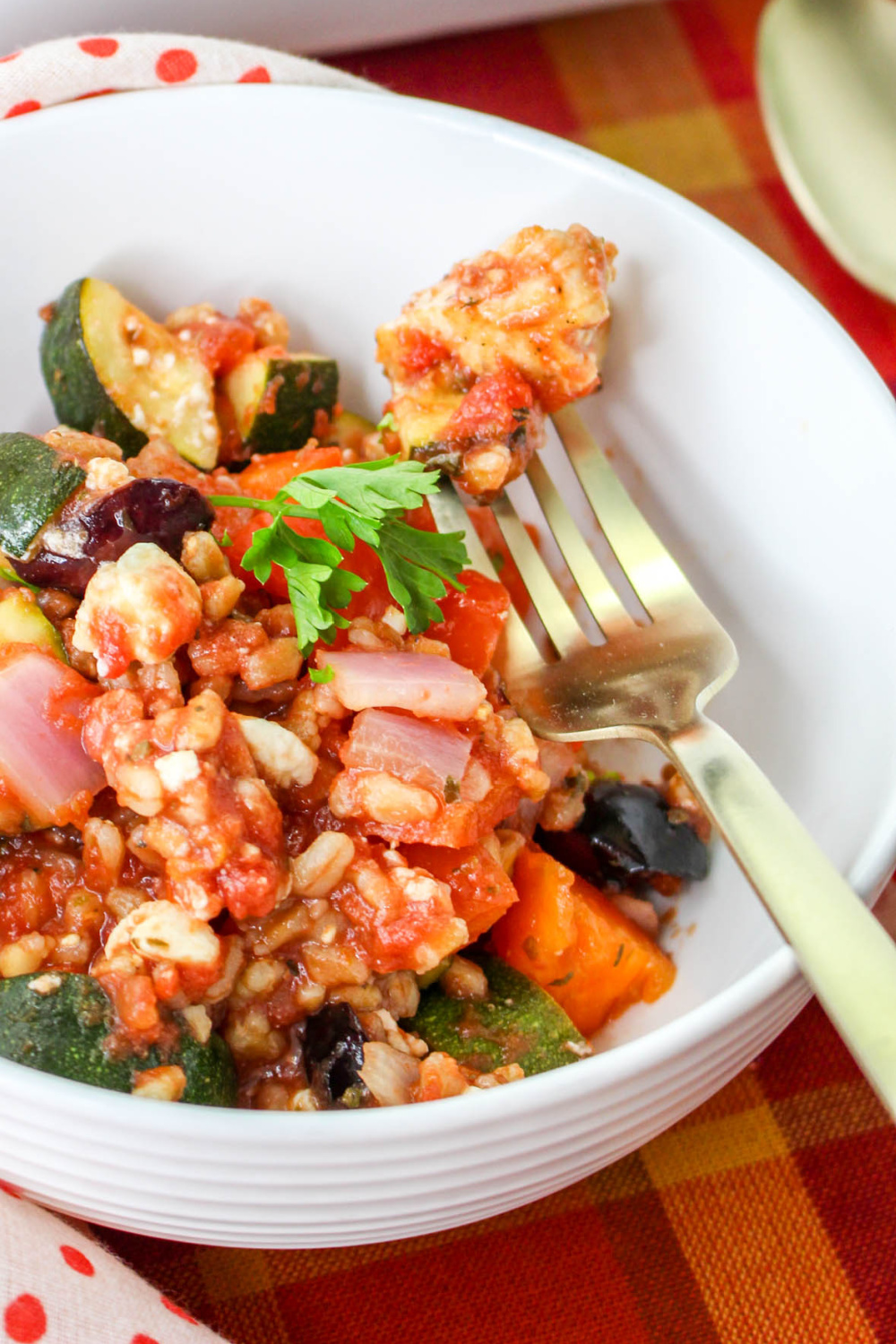 Delicious Mediterranean Chicken Casserole in a white bowl with a fork,