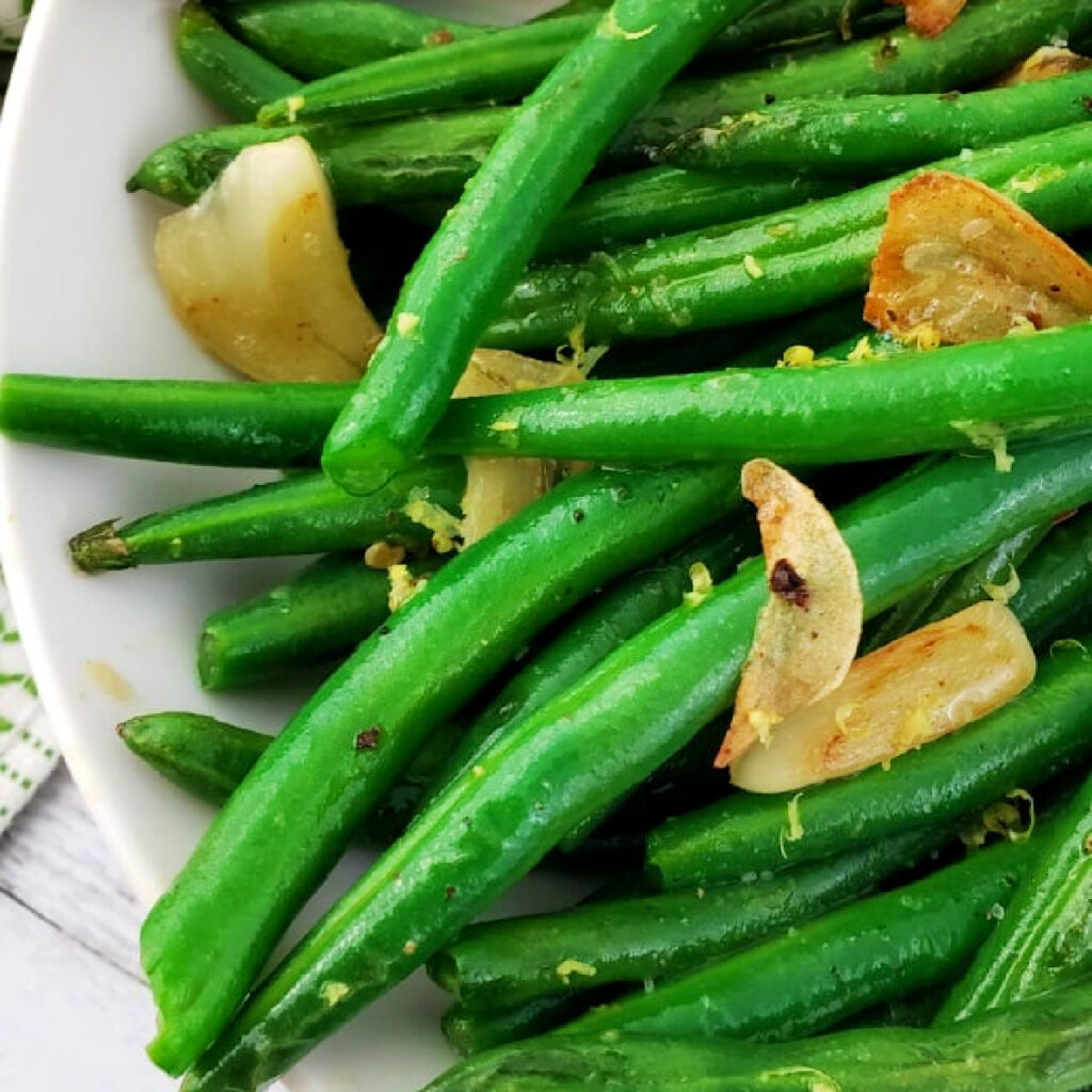 Close up of Garlic-Green-Beans on a white plate.