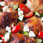 Close up of Mediterranean Sheet Pan Chicken Dinner with tomatoes, feta, and cucumbers.