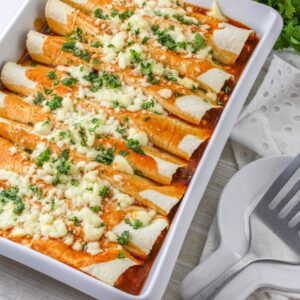 Close up of Shredded Beef Enchiladas in a baking dish.