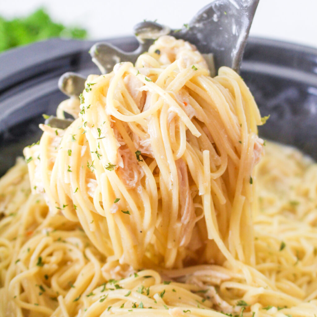 Slow Cooker Angel Chicken Pasta being scooped from a slow cooker.