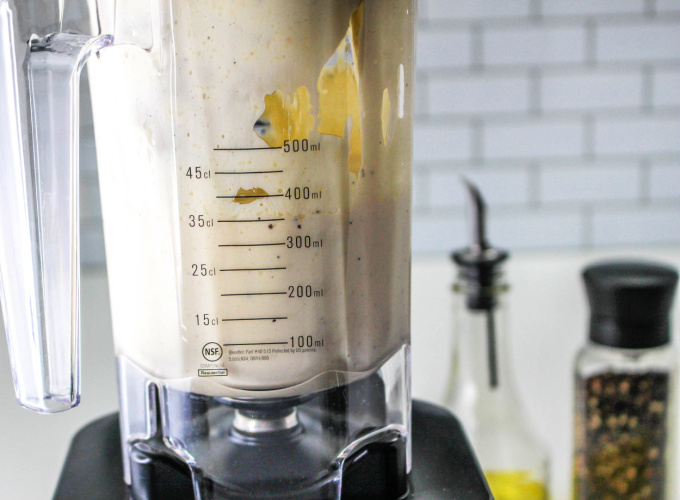 Blender with ingredients for making creamy Caesar Dressing Without Anchovies.