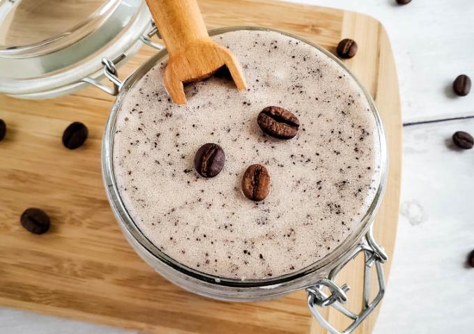 Coffee Sugar Scrub in a jar with a scoop.