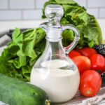 Homemade Buttermilk Ranch Dressing in a cruet next to vegetables.