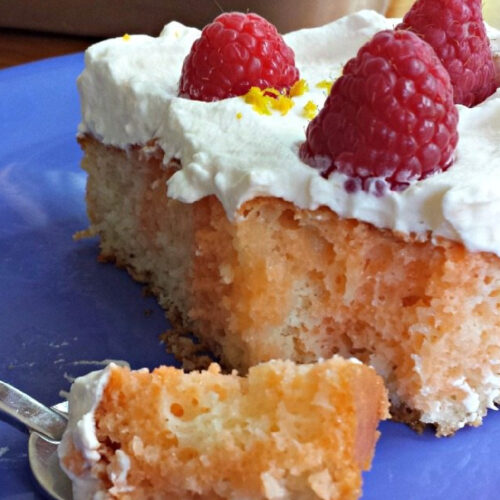 Orange Raspberry Poke Cake on a blue plate.