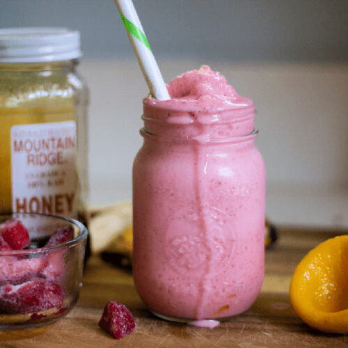 Strawberry Smoothie in a mason jar with a straw,