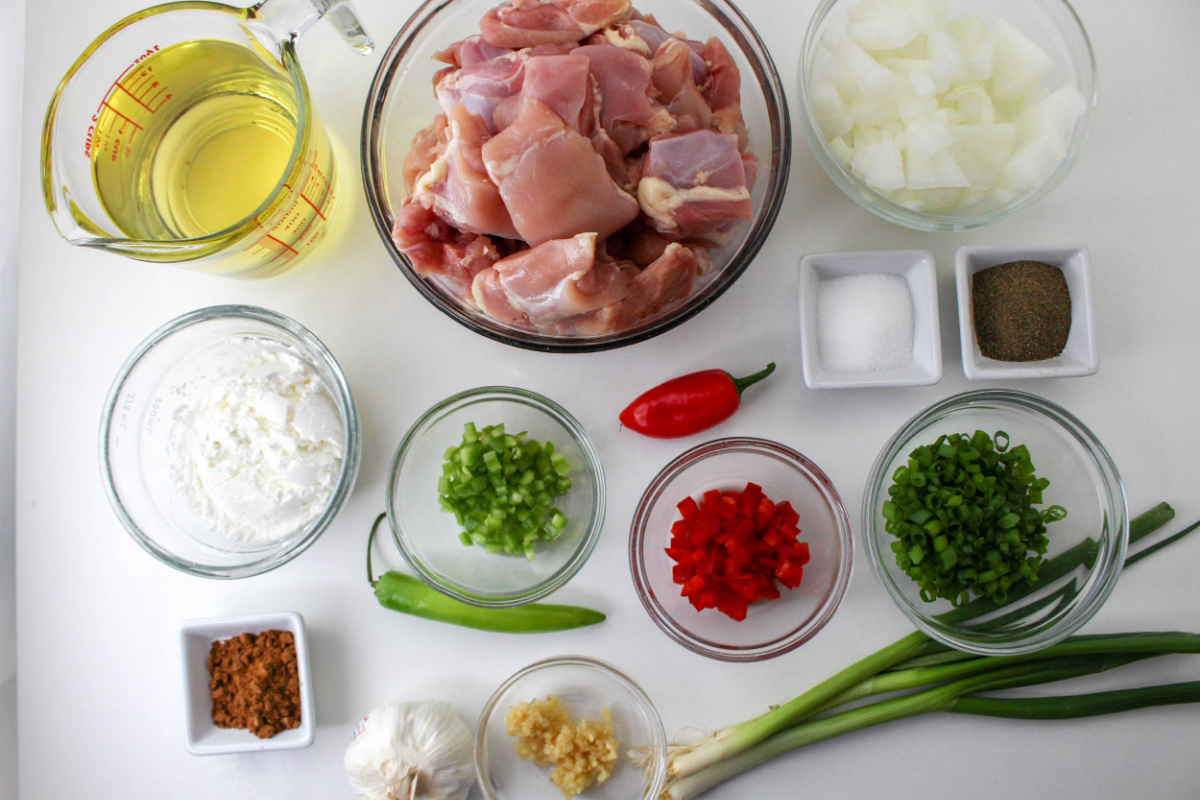 Ingredients in bowls for Chicken Recipe on a white countertop.