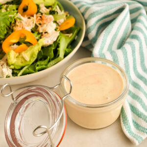 Southwest Dressing in a small jar next to a salad.