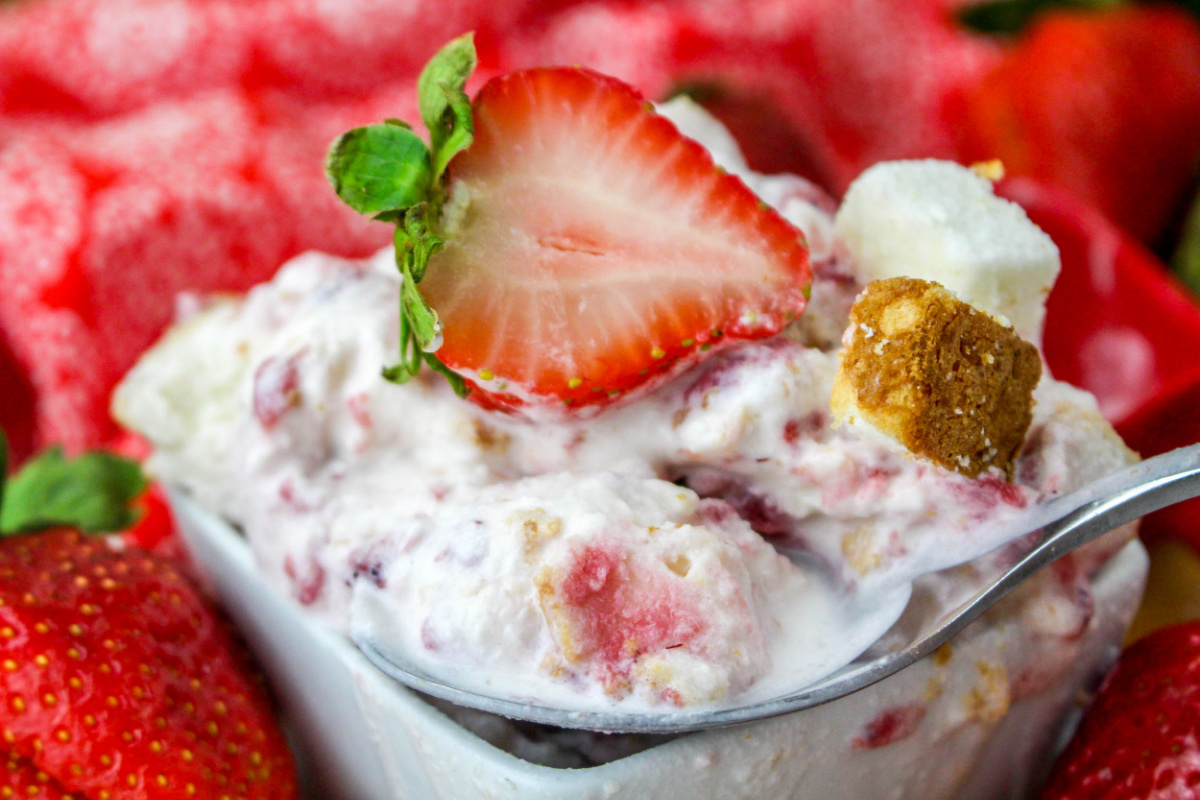 Close up of Strawberry Shortcake Ice Cream in a small square dish with a fresh strawberry.