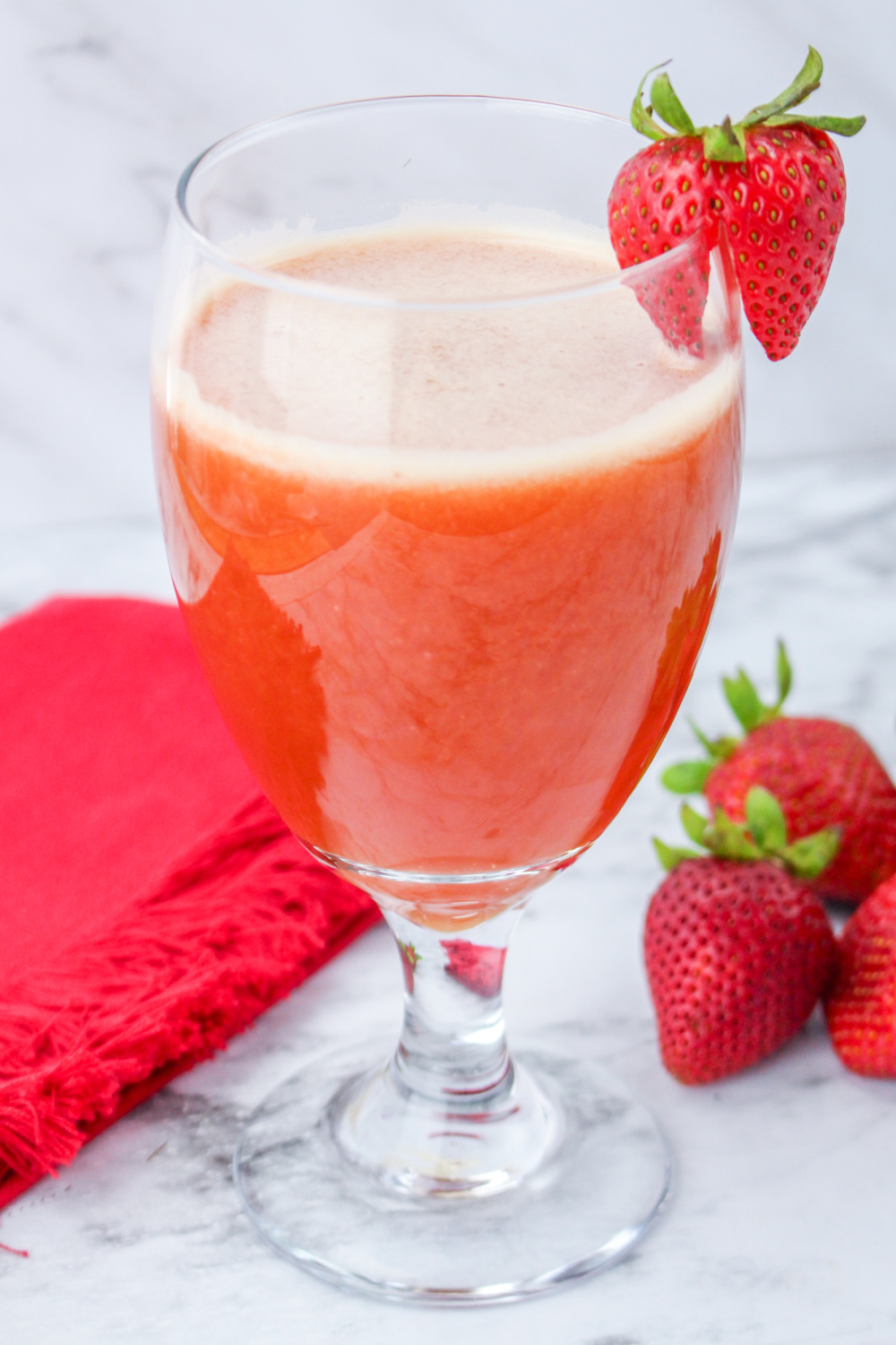 Glass with Chilled Strawberry Tea garnished with a fresh strawberry.