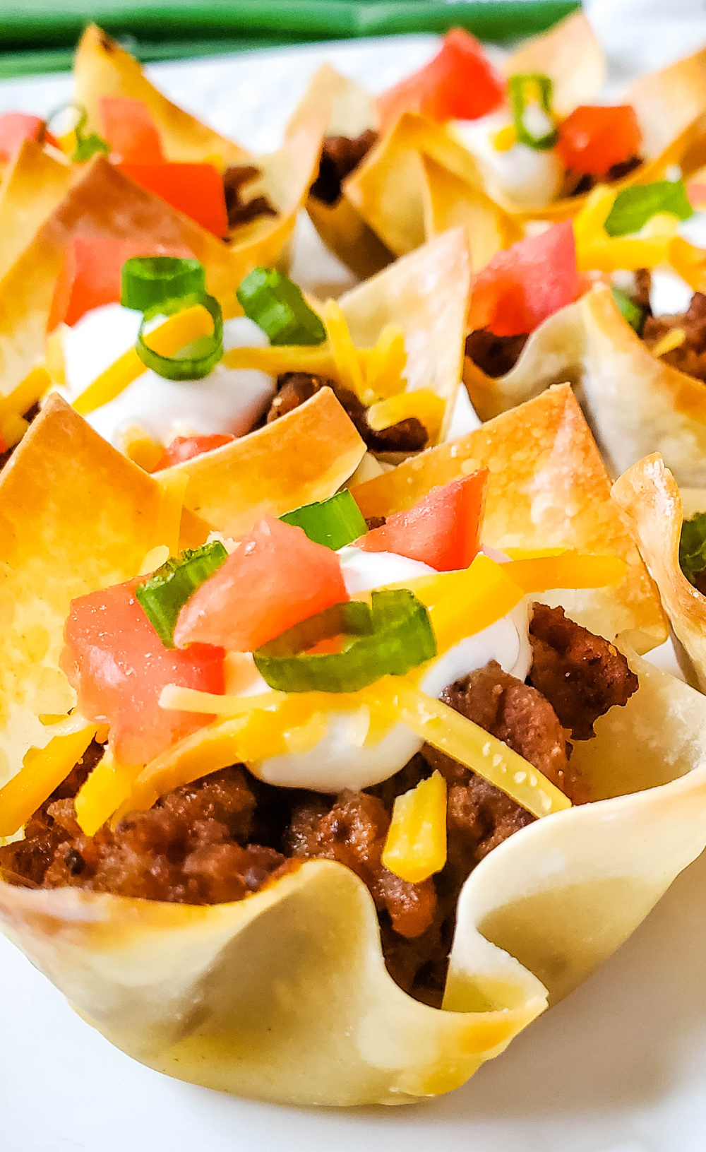 Close up of Taco Wontons with green onions and tomatoes.