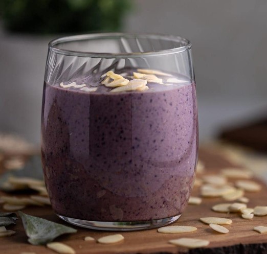 Blueberry tahini smoothie in a small glass.