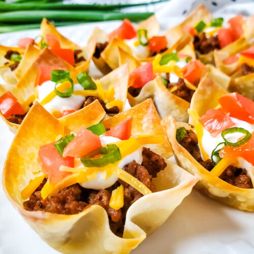 Close up of Taco Wontons with green onions and tomatoes.
