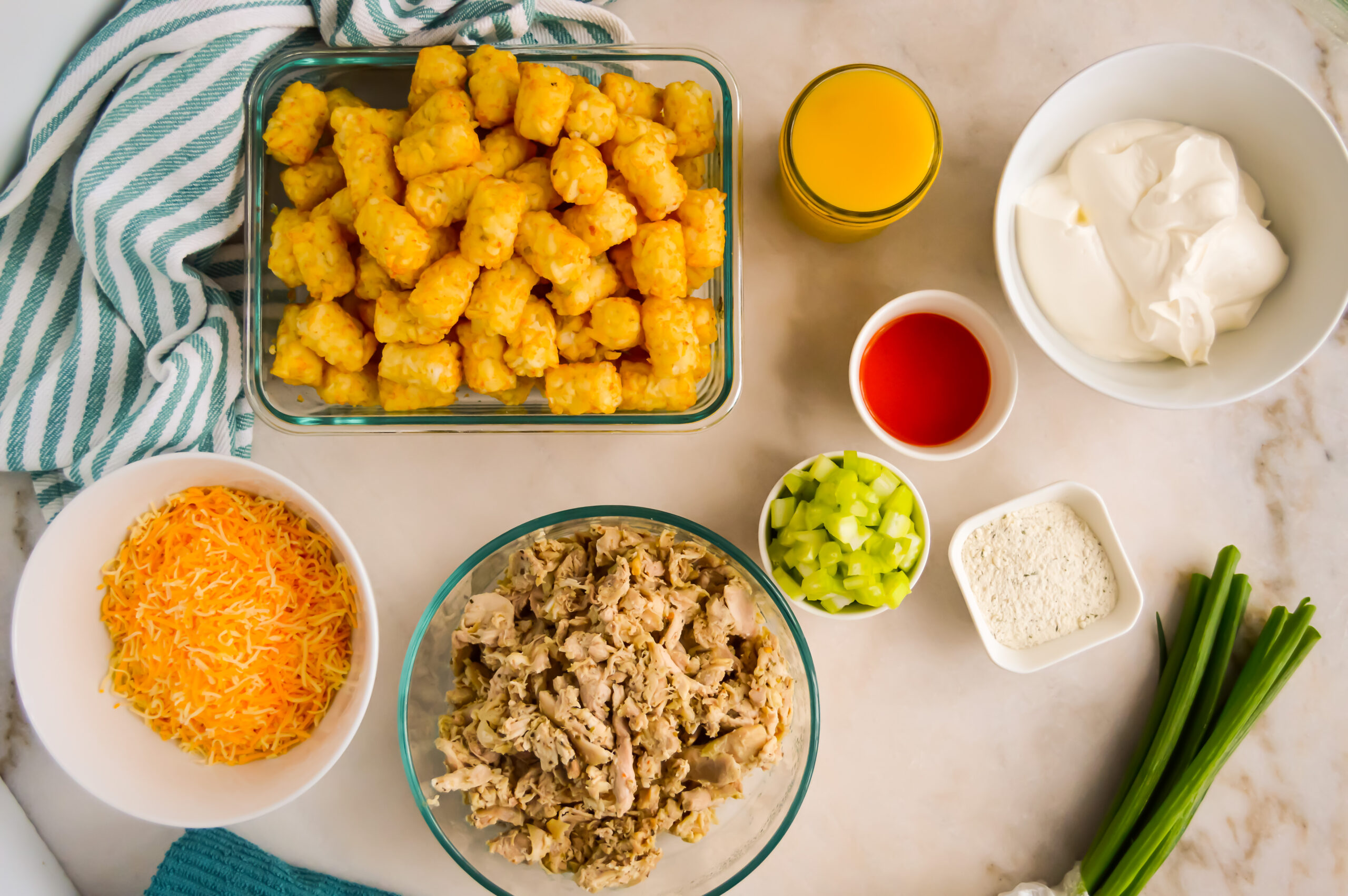 Buffalo chicken tot casserole ingredients on a countertop.