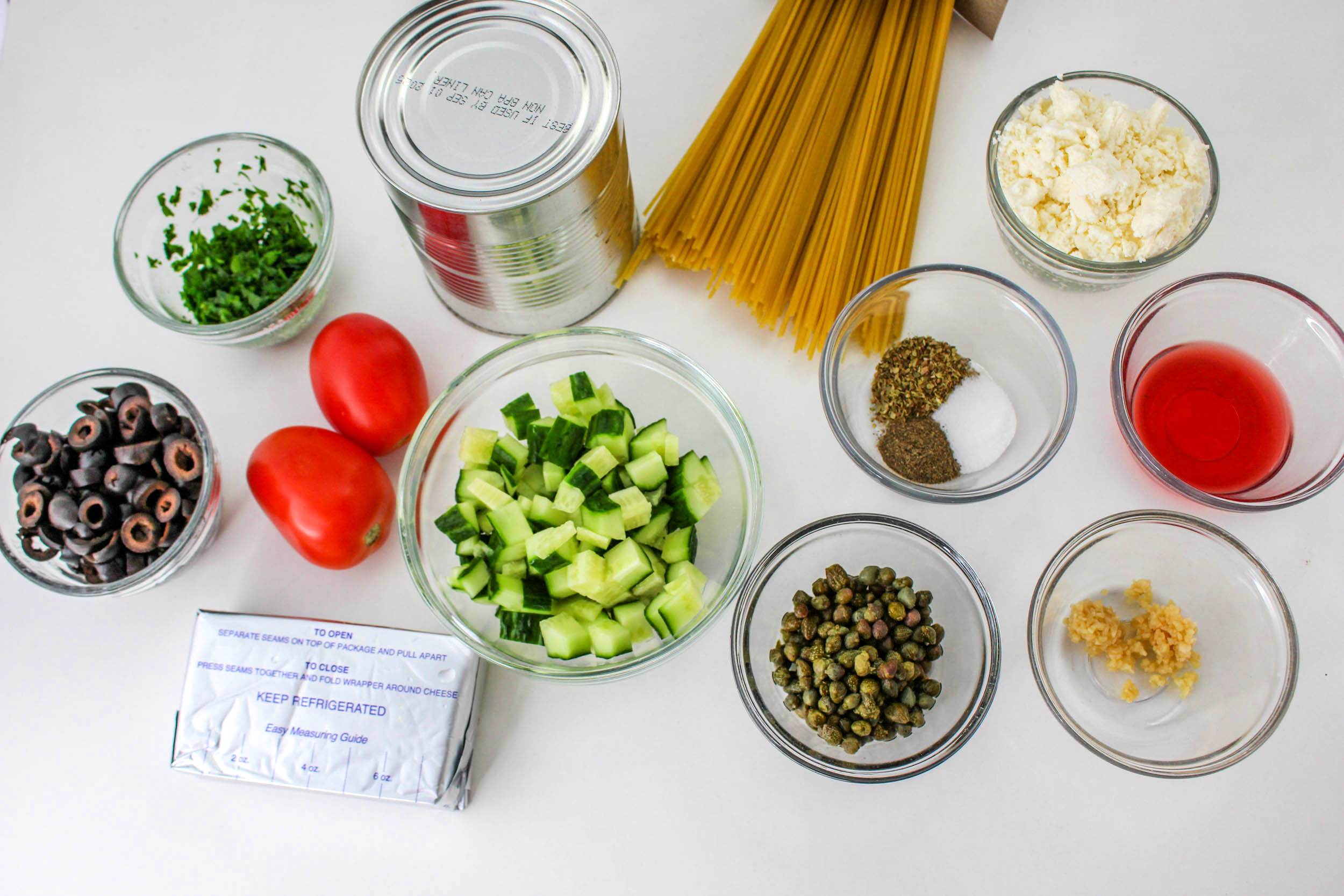 Greek Spaghetti Ingredients in bowls on a countertop.