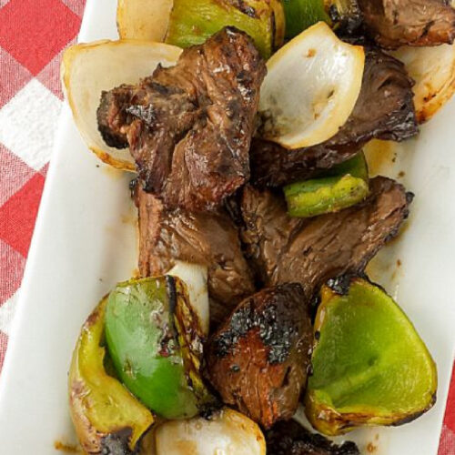 Grilled Teriyaki Beef Kabobs with peppers and onions on a white platter.