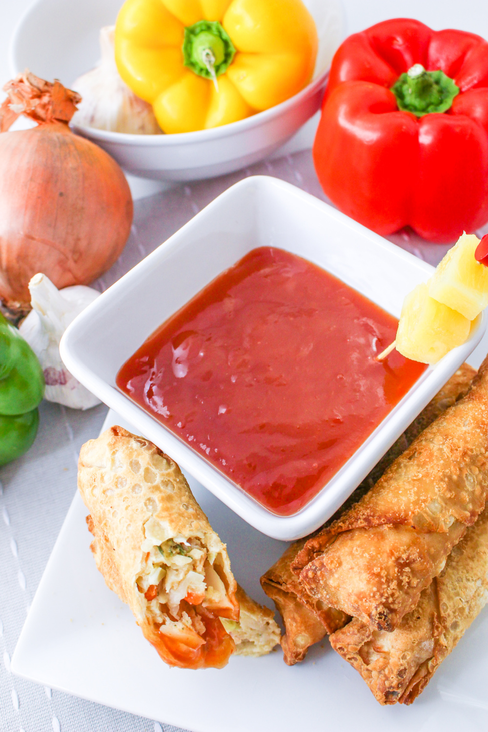 Pineapple Sweet and Sour Sauce in a bowl next to an egg roll.