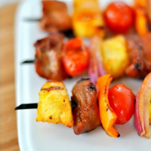 Close-up of Asian Pork Kabobs with pineapple, peppers, onions, and tomatoes.