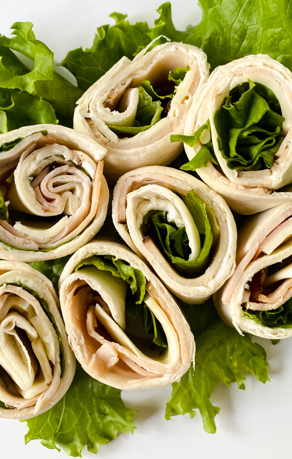 Turkey Pinwheels with greens on a platter.