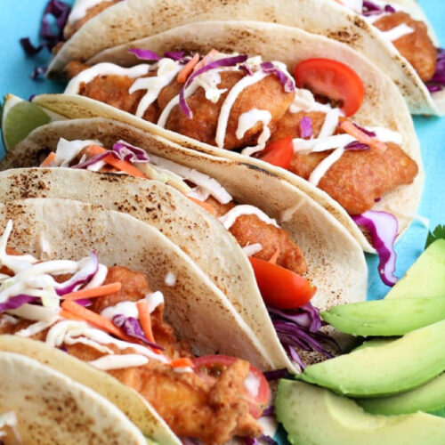 Close up of Baja Fish Tacos with creamy fish sauce in flour tortillas.