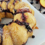 Blueberry Monkey Bread dusted with powdered sugar on a platter.
