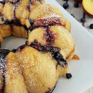 Blueberry Monkey Bread dusted with powdered sugar on a platter.
