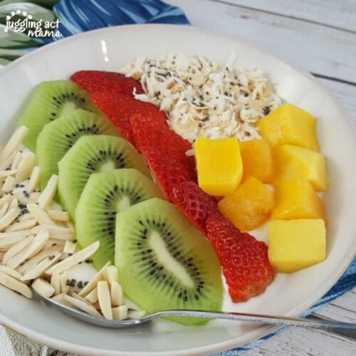 Greek Yogurt Smoothie Bowl topped with kiwi, strawberries, mango, almonds, and toasted coconut.