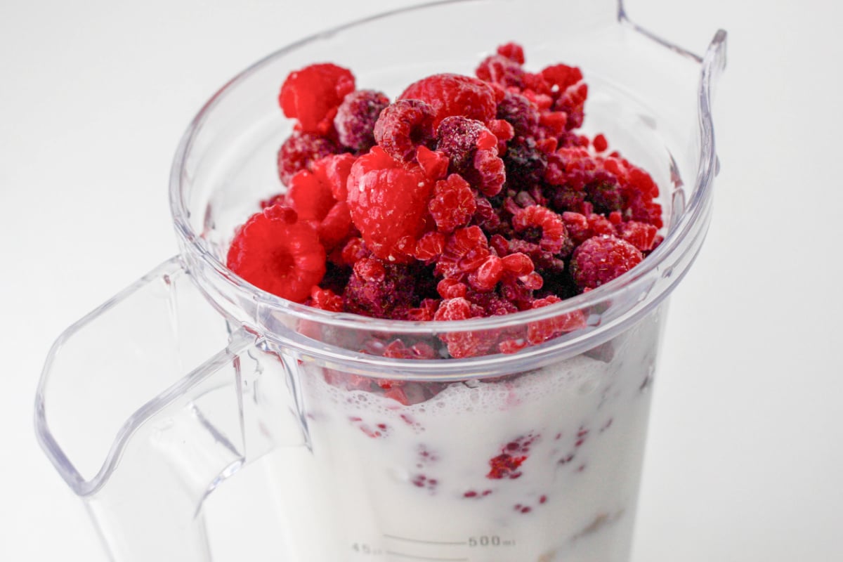 Raspberry Strawberry Smoothie ingredients in a blender.