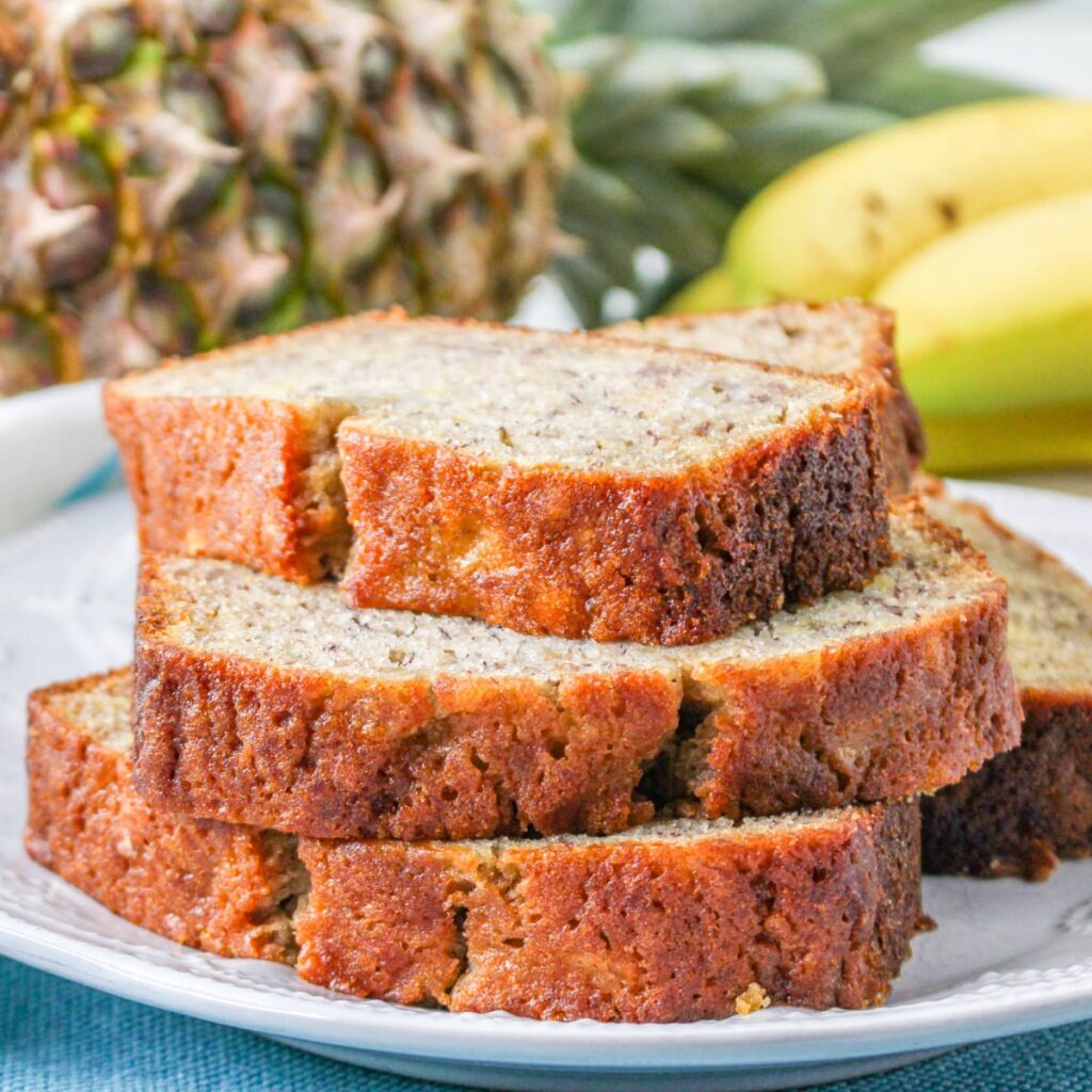 Stacked slices of Pineapple Banana Bread on a plate.