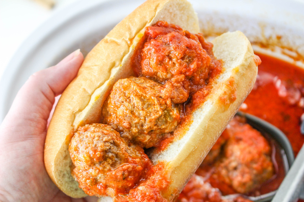 Hand holding a Slow Cooker Meatball Sub.