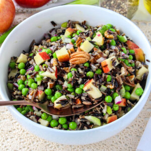 Wild Rice Salad with apples, peas, and pecans in a white bowl.