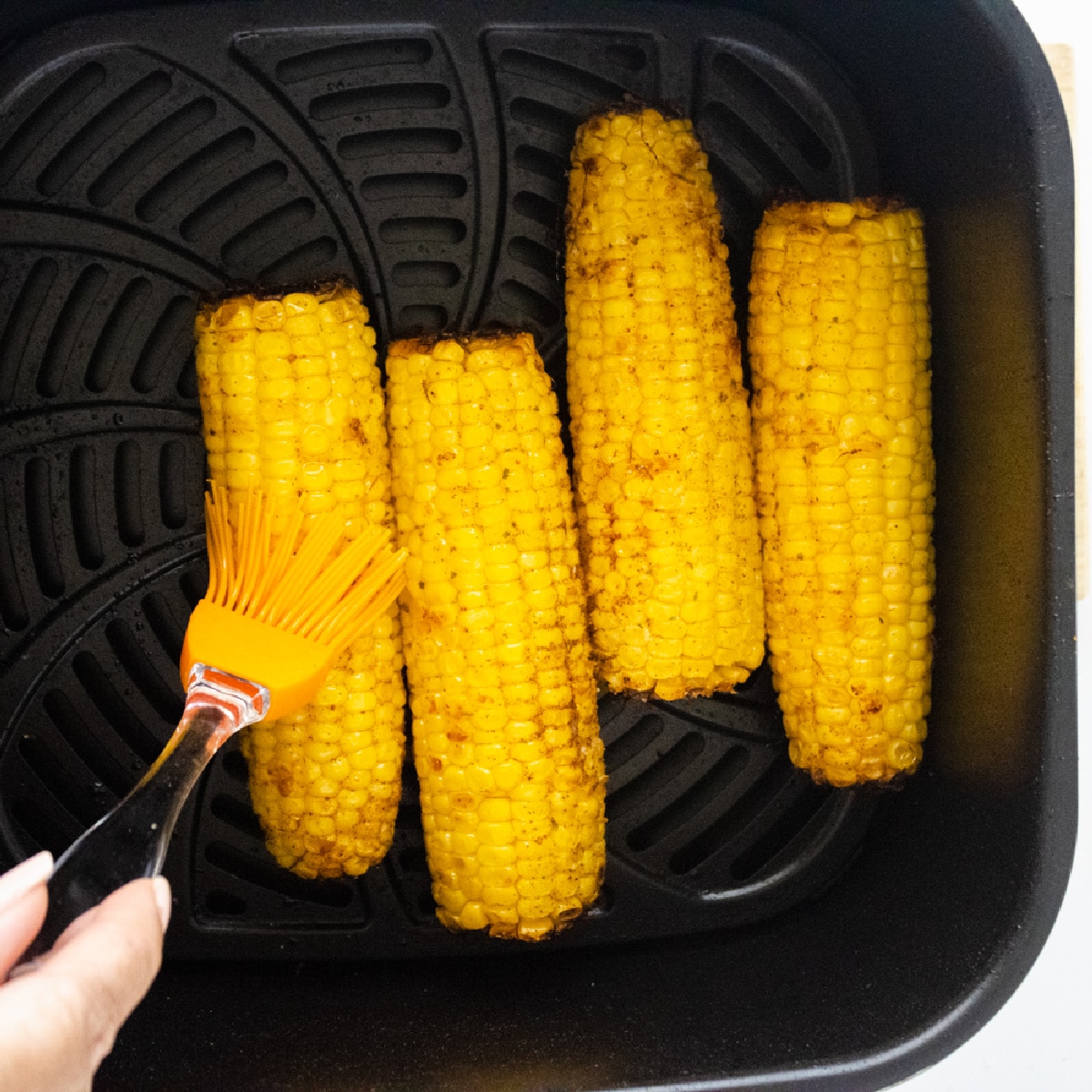 Corn on the Cobb in an Air Fryer basket.
