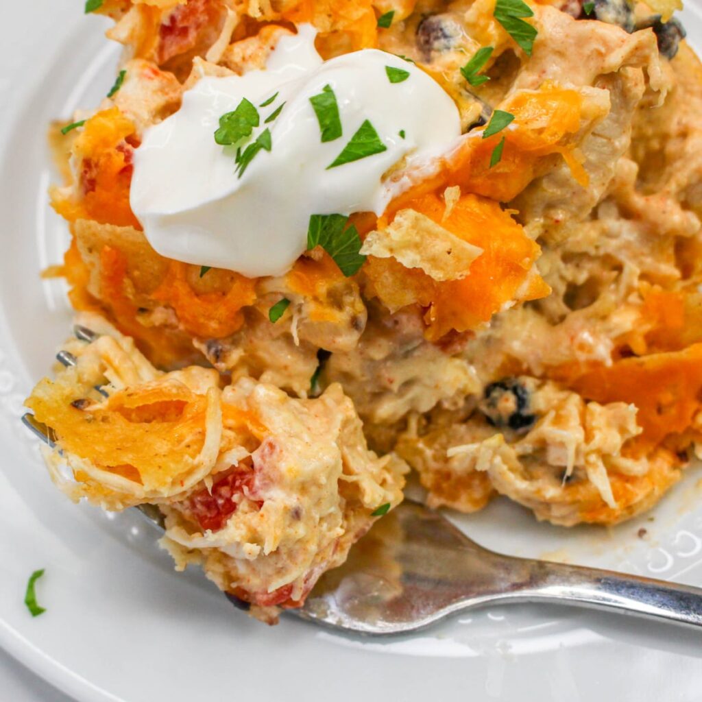 Close up of Easy Chicken Taco Casserole and a fork with sour cream on top.