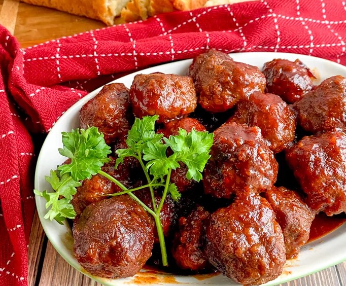 Recipes Using Meatballs: Slow Cooker Cranberry Chili Meatballs from Eat Move Make on a platter with parsley.
