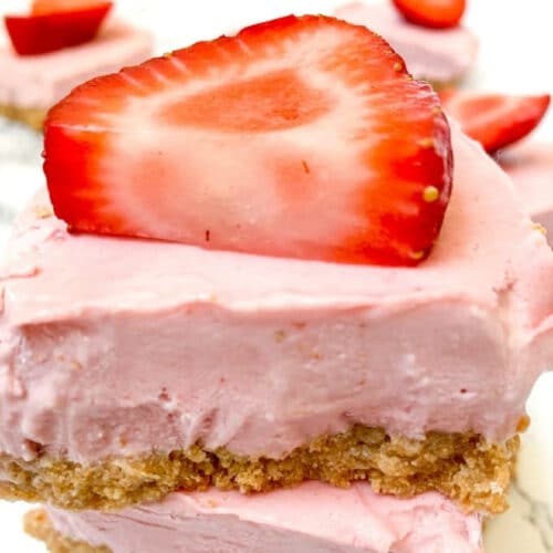 Close up of fresh strawberry slice on top of Strawberry Cheesecake Bars.
