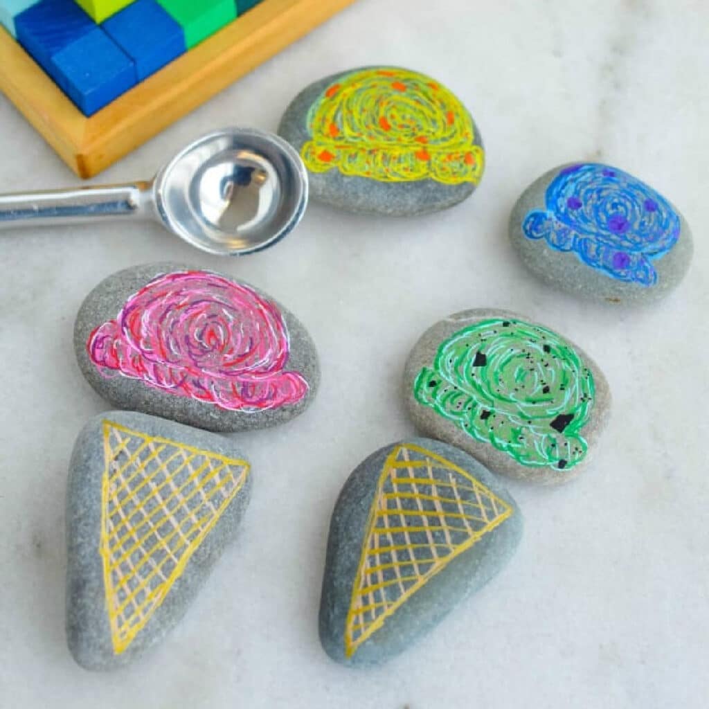 Smooth rocks painted with ice cream cones and scoops of ice cream,