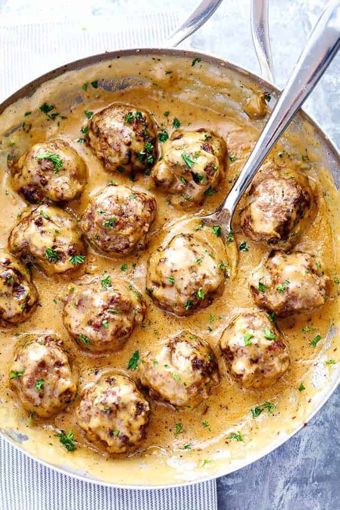 Top down view of Swedish meatballs in a skillet with a spoon.